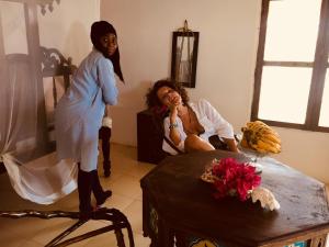 a woman standing next to a woman sitting on a table at Vanilla House in Jambiani