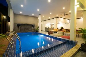 una piscina en una casa con sala de estar en Noni Tree Hostel, en Siem Reap