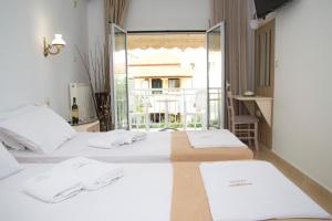 a bedroom with two beds and a balcony at Hotel Astron in Myrina