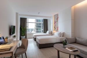 a living room with a couch and a table at Jasmine 59 Hotel in Bangkok