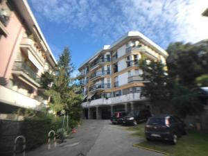 Un grand bâtiment avec des voitures garées dans un parking dans l'établissement Appartamento del Golf - Secured Parking -, à Rapallo