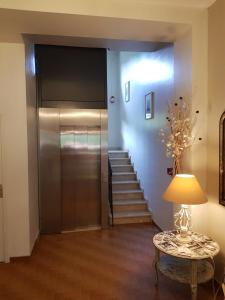 a hallway with a elevator and a table with a lamp at Hotel Cyrnea in Calvi