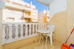 a small white table and chair on a balcony at ALEGRIA ID118 in Torrevieja +20 photos