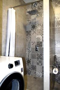 y baño con ducha y lavadora. en Apartment on Volodymyra Stelmakha 1b en Rivne