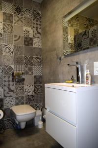 a bathroom with a toilet and a sink and a mirror at Apartment on Volodymyra Stelmakha 1b in Rivne