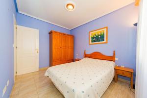 a bedroom with a bed and a blue wall at ALEGRIA ID118 in Torrevieja