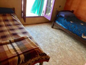 1 dormitorio con 2 camas y ventana en La Lila, en Barra de Valizas