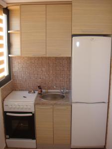 uma cozinha com um frigorífico branco e um lavatório em Apartments Orfej em Sveti Stefan