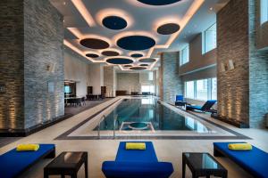 einen Pool in einem Gebäude mit Pool in der Unterkunft Centara West Bay Hotel & Residences Doha in Doha