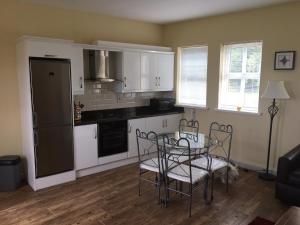 - une cuisine avec une table et des chaises dans la chambre dans l'établissement Curraghchase Cottage, à Kilcornan