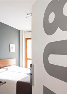 1 dormitorio con 2 camas y un cartel de manzana en la pared en Hospedium Hostal Un Punto Chic, en Huesca