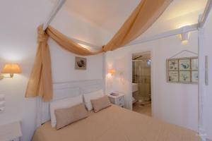 a bedroom with a large bed and a bathroom at Vardia Bay Studios in Karavostasi