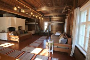 LAURI Historical Log House Manor في روفانييمي: غرفة معيشة مع أريكة ومدفأة