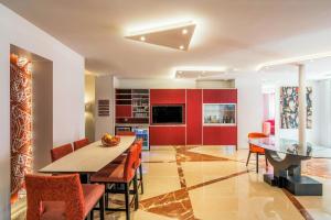 a kitchen with red cabinets and a table and chairs at Mercure Paris Pont de Levallois Neuilly in Levallois-Perret