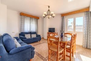a living room with a blue couch and a table at Casablanca in Pinos del Valle