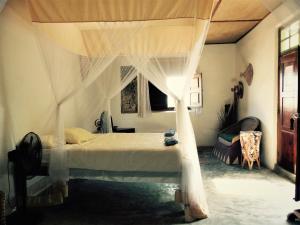 a bedroom with a bed with a canopy at Miti Miwiri in Ibo