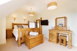 a bedroom with a bed and a desk and a mirror at Unit 1 Dove Farm Barns in Stoke on Trent