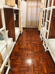 Camera con pavimenti in legno e letti a castello. di Sanga Hostel a Pakse