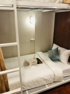 a white bunk bed with a stuffed animal on it at Sanga Hostel in Pakse