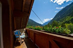 une chaise bleue sur un balcon avec vue sur les montagnes dans l'établissement Gasthof Innerfraganterwirt, à Flattach