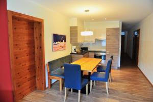 una cucina e una sala da pranzo con tavolo e sedie in legno di Sölle Homes Nassfeld a Sonnenalpe Nassfeld