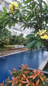 una piscina en el medio de un edificio con flores en Studio28 at Clove Garden, en Bandung