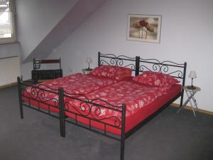 ein Schlafzimmer mit einem roten Bett mit roten Kissen in der Unterkunft Ferienwohnung Pforzheim in Pforzheim