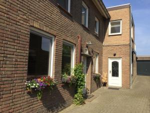 a brick house with flower boxes on the side of it at Klein Haasdal Studio's in Schimmert