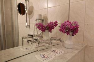 un mostrador con gafas y flores púrpuras. en Hotel Weisser Schwan, en Erfurt