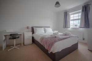 a bedroom with a bed and a desk and a window at The Robin Coach House by RentMyHouse in Hereford