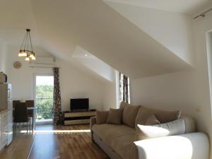 a living room with a couch and a tv at Apartments Sunrise in Tivat