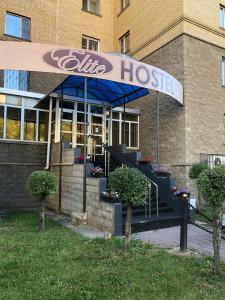 a building with a blue hoc sign in front of it at Elite Hostel in Astana