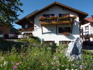 a building with flowers in front of it at Pension Epple in Oberjoch
