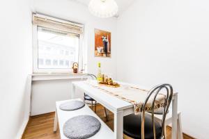 eine weiße Küche mit einem weißen Tisch und Stühlen in der Unterkunft Workers Apartment am Wiener Platz in Köln + 10 Fotos