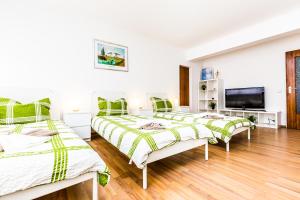 ein Zimmer mit drei Betten und einem Flachbildfernseher in der Unterkunft Workers Apartment am Wiener Platz in Köln