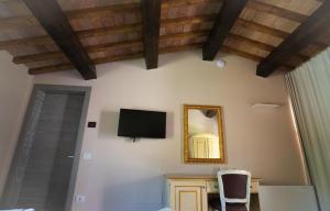 una camera con televisore, tavolo e sedia di Borgo Rossi a La Strada