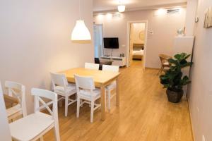 a dining room and living room with a table and chairs at Apartamento Melina Arlu - Centro Historico in Málaga