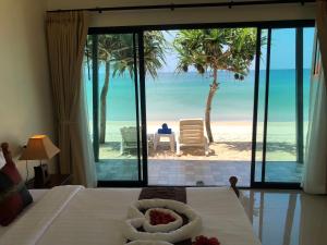 a bedroom with a bed with a view of the beach at Lanta Seafront Resort in Ko Lanta