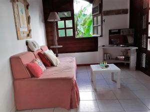 a living room with a pink couch and a table at Chez Karine & Harold in Sainte-Luce