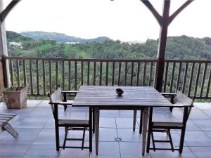 d'une table et de chaises en bois sur un balcon avec vue. dans l'établissement Chez Karine & Harold, à Sainte-Luce