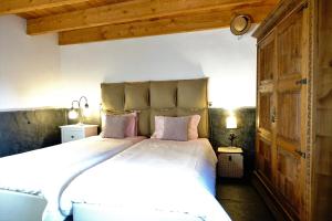 瓦隆古的住宿－Porto Natura House，卧室配有带粉红色枕头的大型白色床