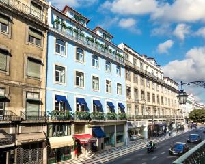 ein blaues Gebäude in einer Stadtstraße mit Autos in der Unterkunft The Lift Boutique Hotel by RIDAN Hotels in Lissabon