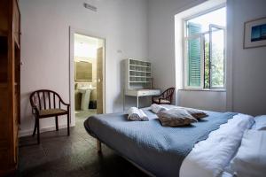 a bedroom with a bed, chair and a window at La Controra Hostel Naples in Naples