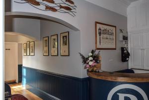 una habitación con un bar con cuadros en la pared en The Randolph Hotel, en Southwold