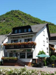 a white building with flowers in front of it at Pension / Ferienwohnungen Scheid in Kestert