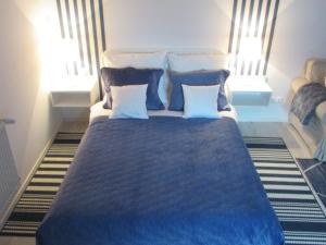a bedroom with a large blue bed with two pillows at Domek w ogrodzie in Kazimierz Dolny +7 photos