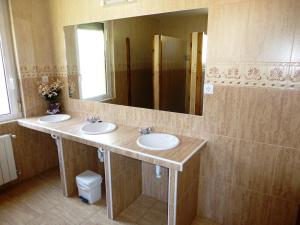 a bathroom with two sinks and a large mirror at Albergue Turístico Briz in Espinama