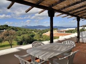 a white table and chairs on a balcony with a view at Capo Ceraso Family Resort in Costa Corallina