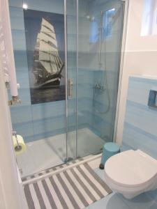 a bathroom with a shower with a boat painting on the wall at Domek w ogrodzie in Kazimierz Dolny