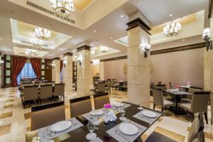 a dining room with tables and chairs and chandeliers at Boudl Mahayel Aseer in Muhayil